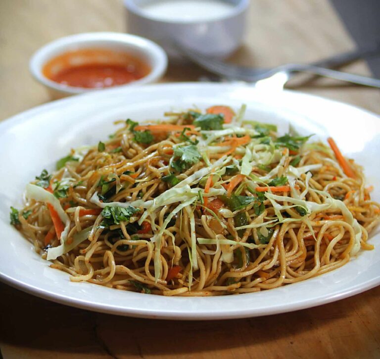 Lo mein on a white place with bean sprout garnish from China King