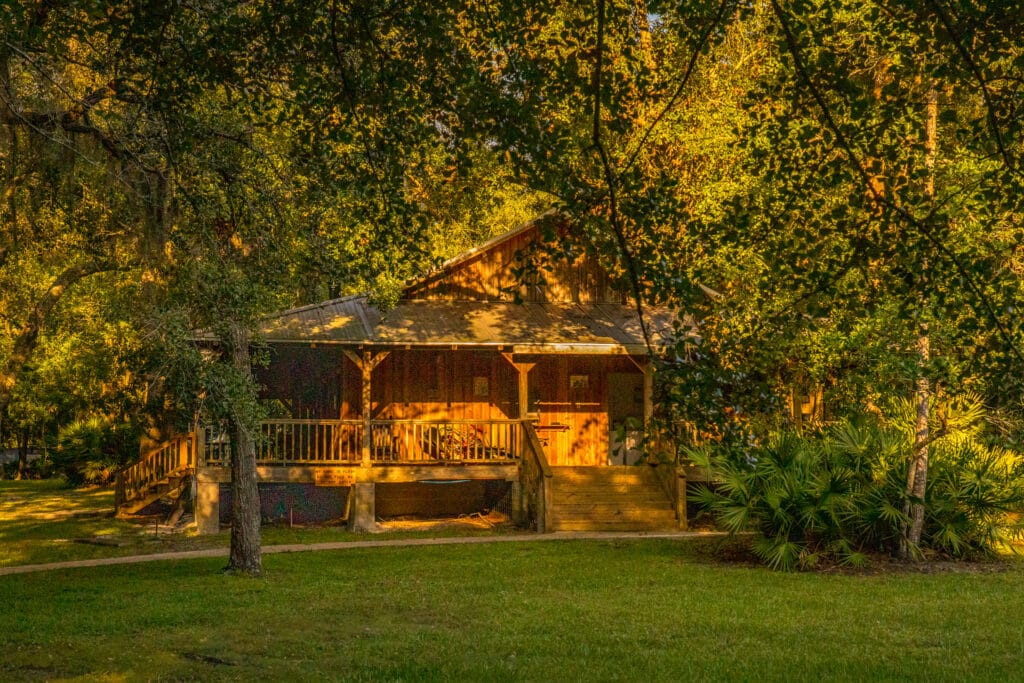 The clubhouse cabin situated at sunset amongst the trees at Country Oaks RV Park & Campground