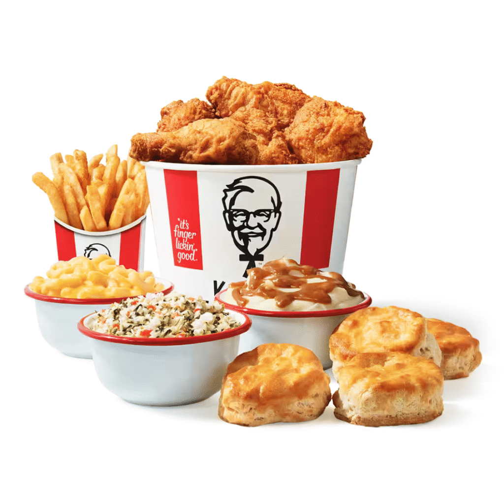 Kentucky Fried Chicken Bucket of Chicken, box of French fries, Bowl of mac and cheese, bowl of cole slaw, bowl of mashed potatoes and gravy, and four biscuits on a white background