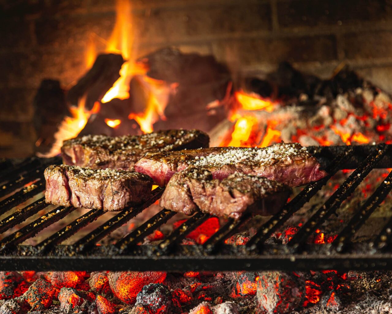 Steak cooking on a flaming grill at LongHorn Steakhouse