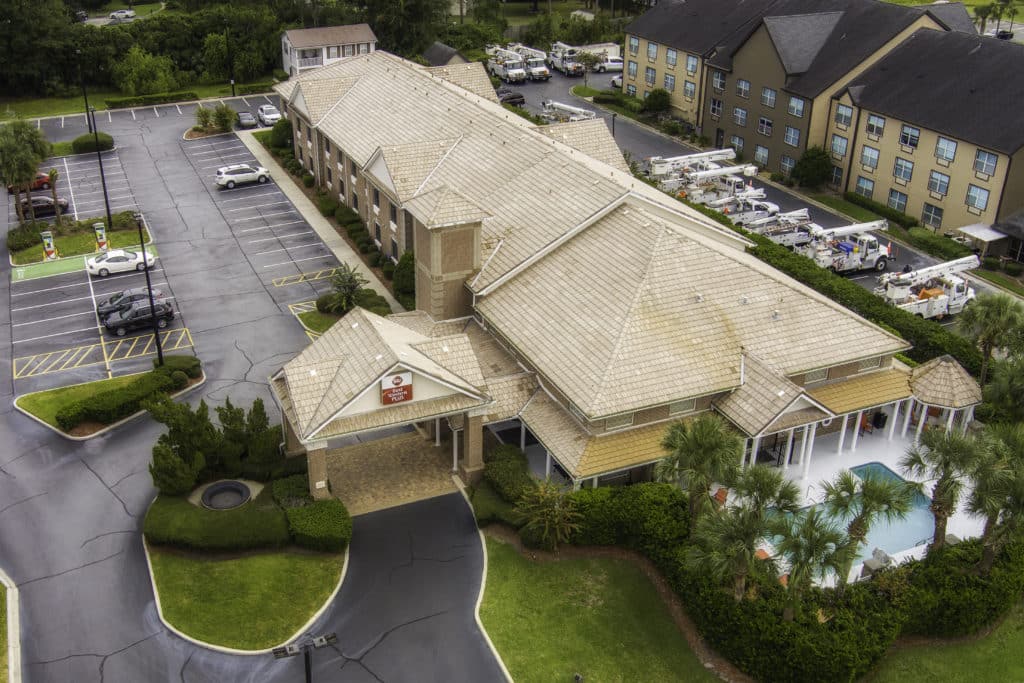 Best Western Plus Kingsland Aerial View of property from southwest with pool on south end of long building and portico on southwest side and parking along the west and north sides
