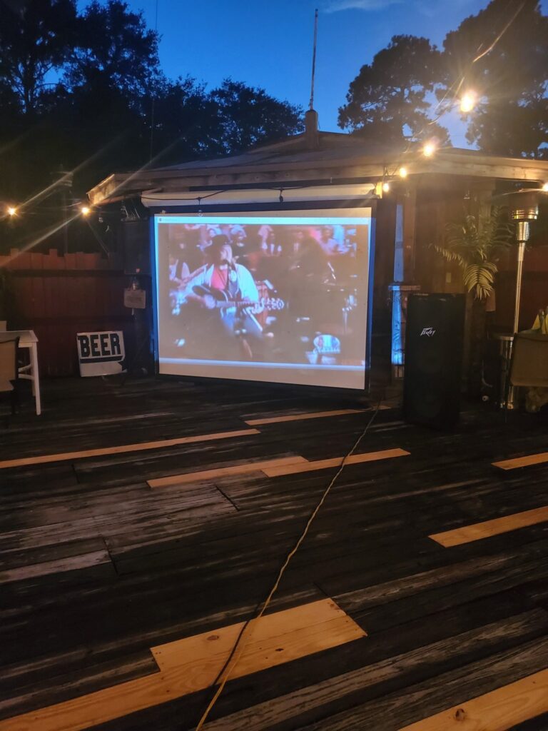 Pirates Point Deck with screen set up for Music Video Karaoke at night time
