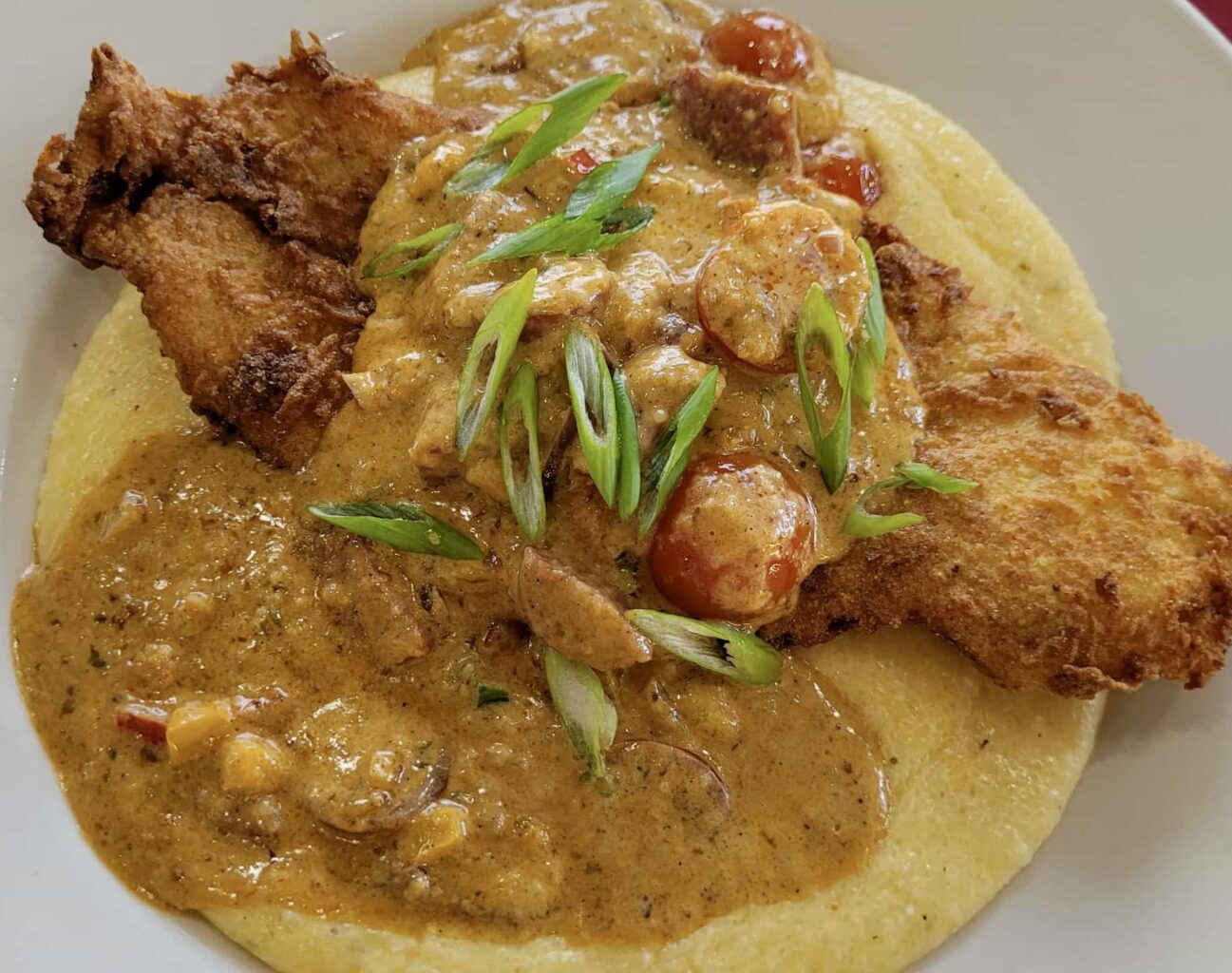 Cajun fried fish and grits in a bowl