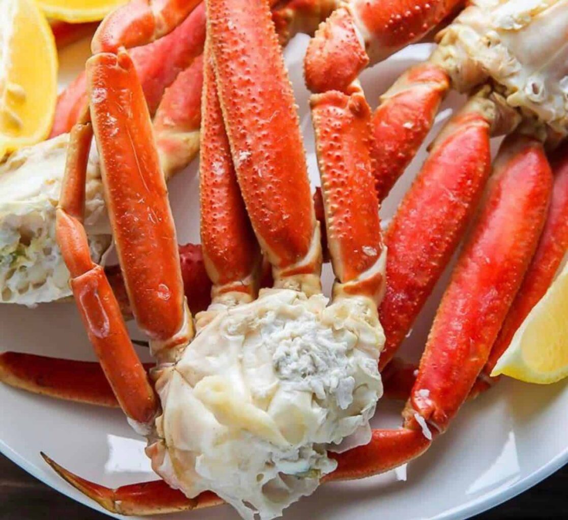 King crab legs on a white plate with lemon wedges from Ship 2 Shore Seafood