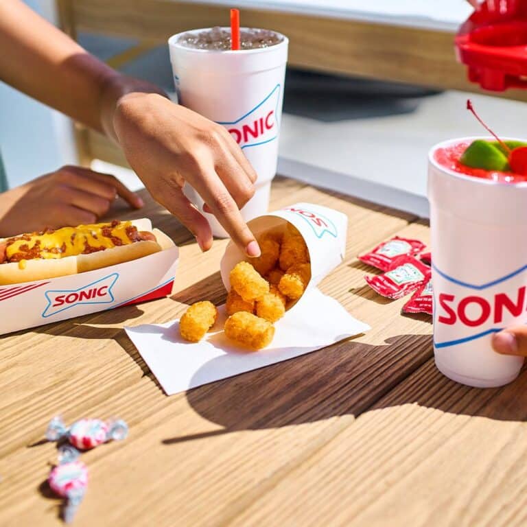 Chili Cheese Dog, Tater Tots, and two drinks with straws in Sonic Branded Styrofoam cups