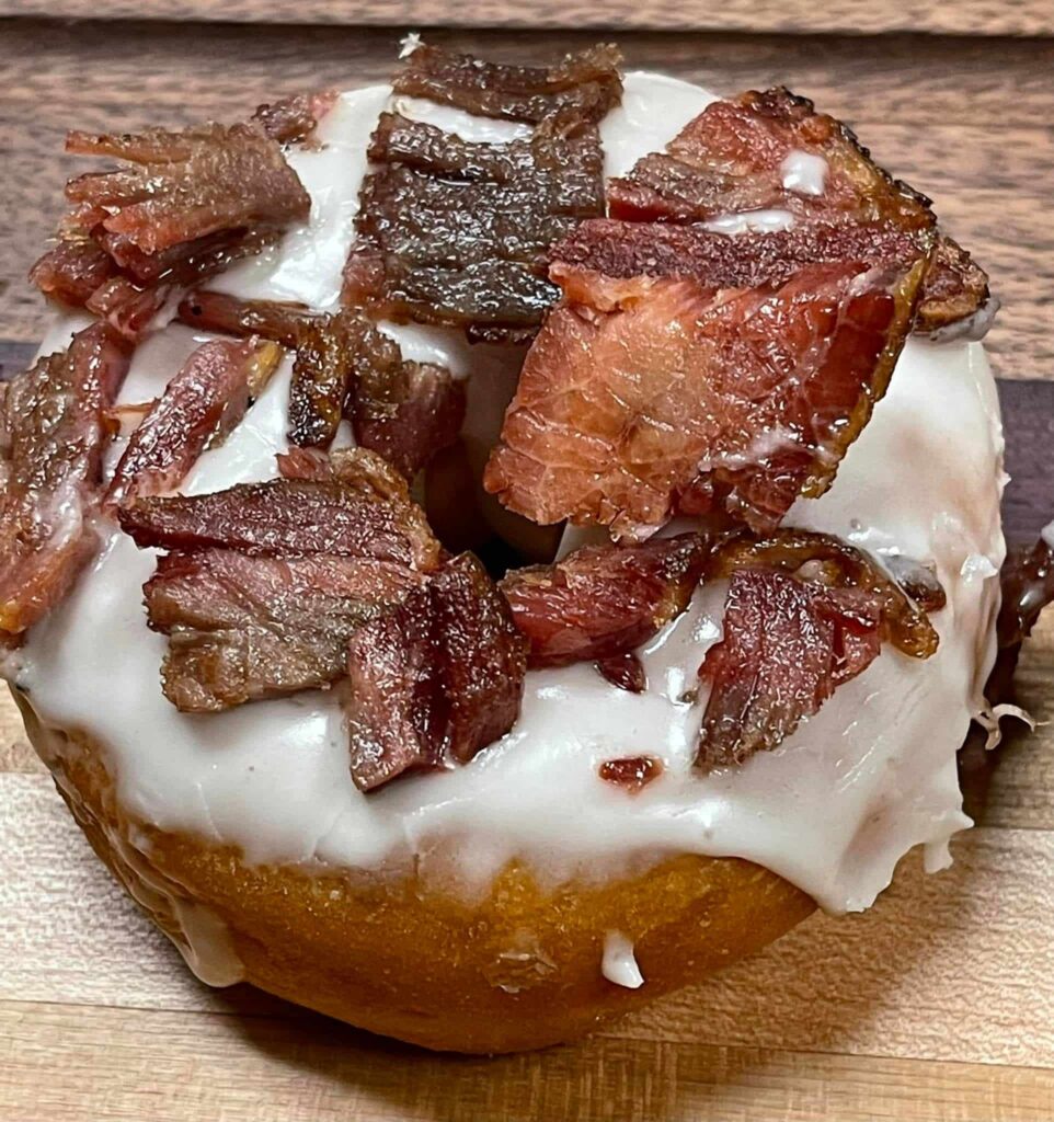 Fresh glazed donut topped with smoked bacon bits from Spouses Bakery