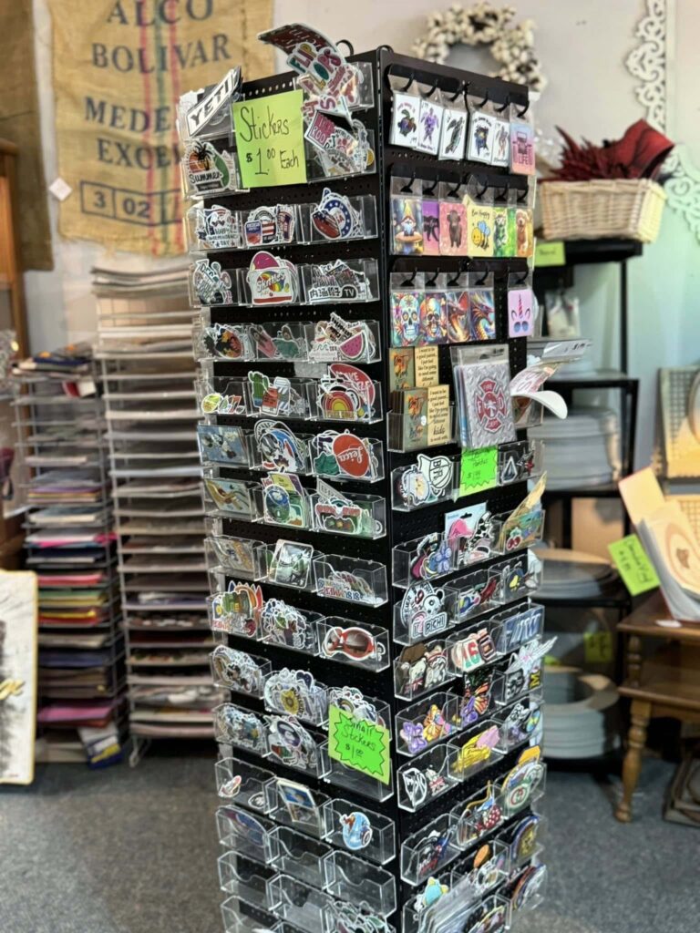 tall rotating rack display of small stickers for craft