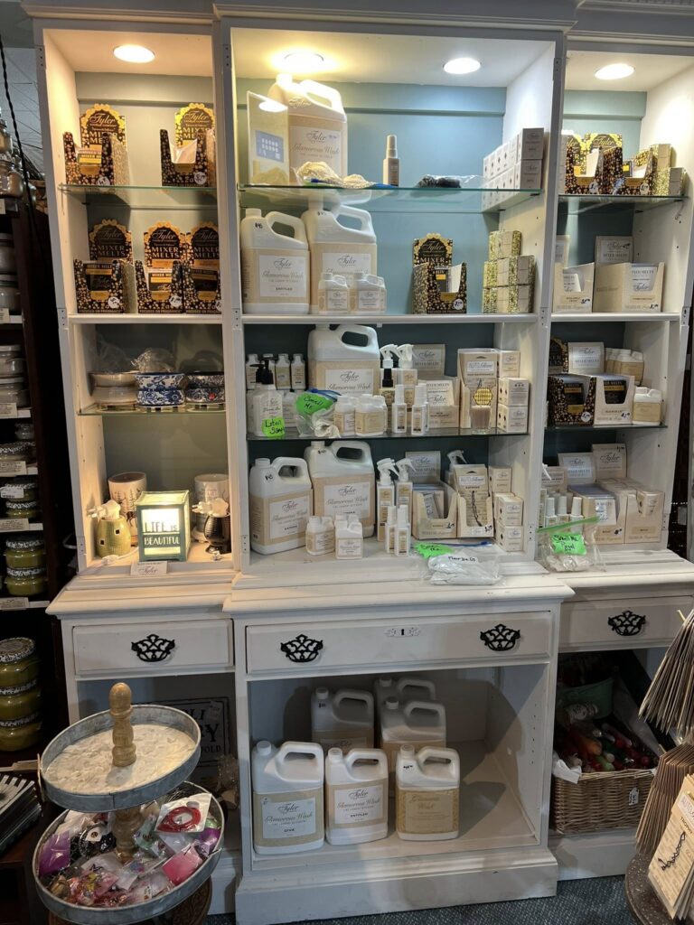 Large white wooden hutch with expansive display of Taylor Candle Company products for candle-making