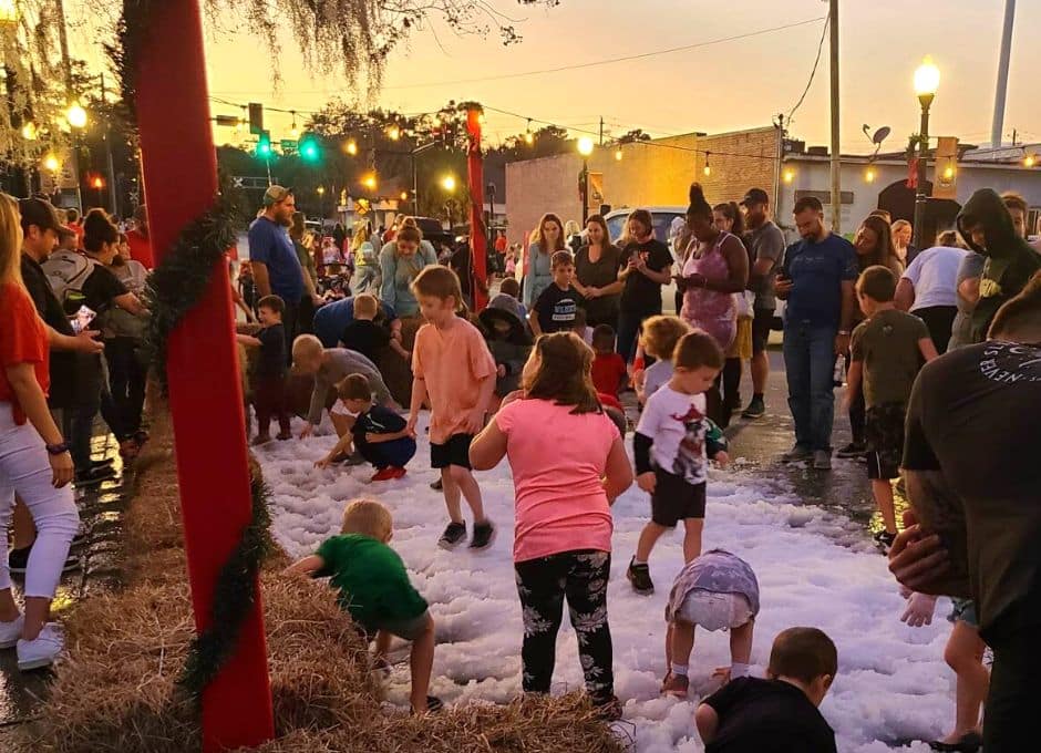 Kids play in snow area of a local Christmas event.