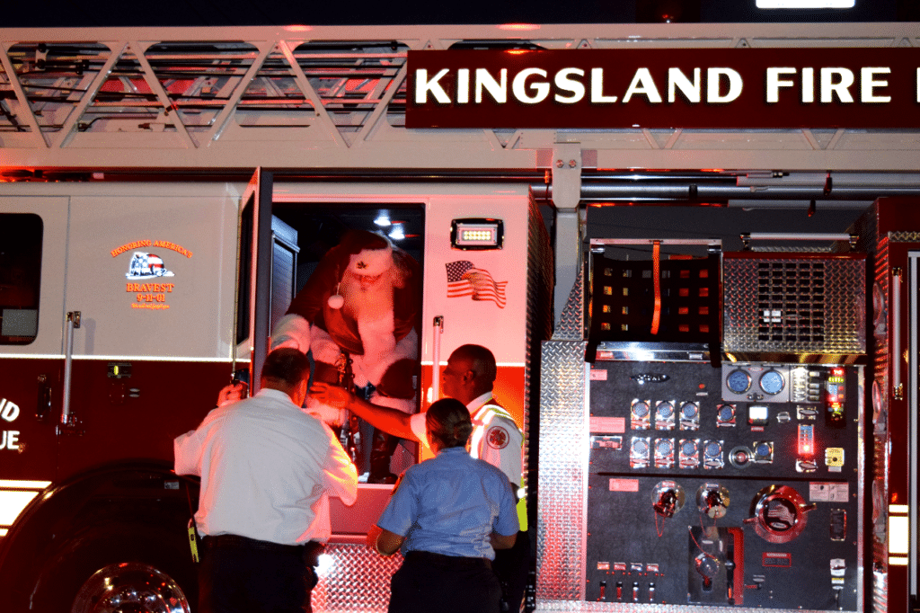 Santa Makes his entrance by climbing out of a firetruck.