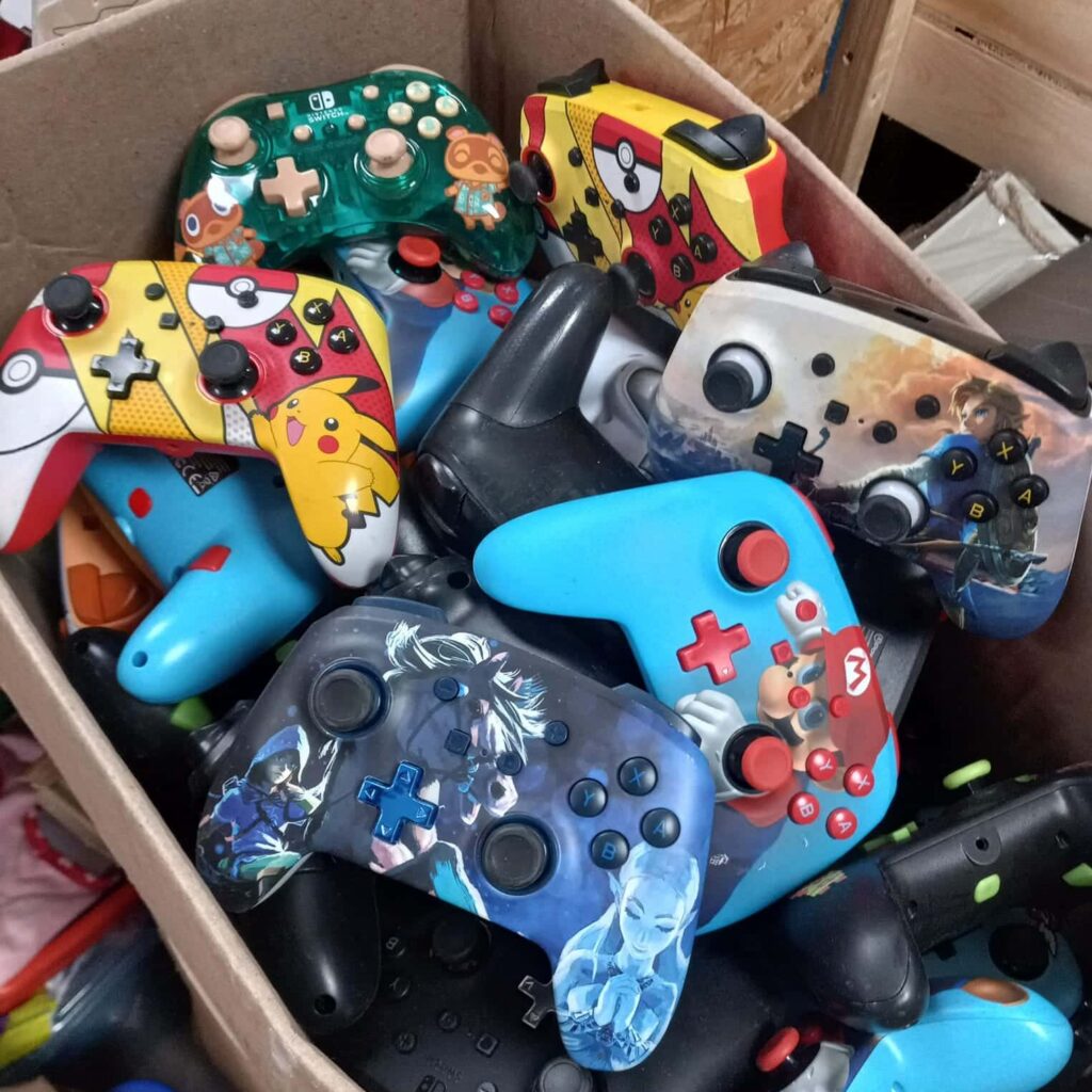 Box of video game controllers of many different bright colors