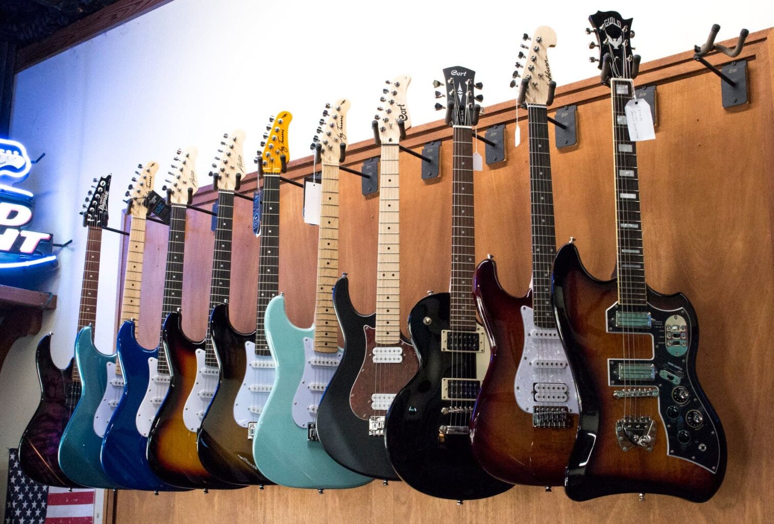 10 electric guitars hanging on a wall display