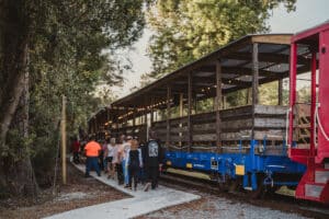 People boarding an open-air train car made of wood