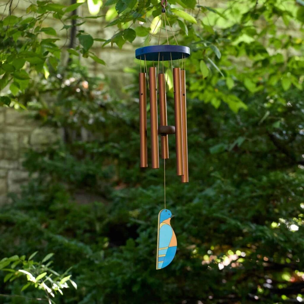 Windchime in front of greenery outside