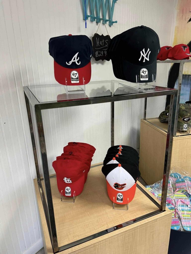 Display of baseball caps from the A's, the Yankees, the Orioles.