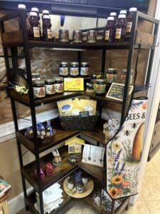 Corner shelf display of Georgia honeys, herbal teas, and bee themed items.