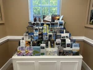 Travel brochures on a large tiered display rack in front of a window.