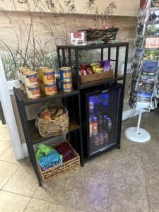 Packaged snacks and candy on display, as well as a small, glass front refrigerator with cold drinks.
