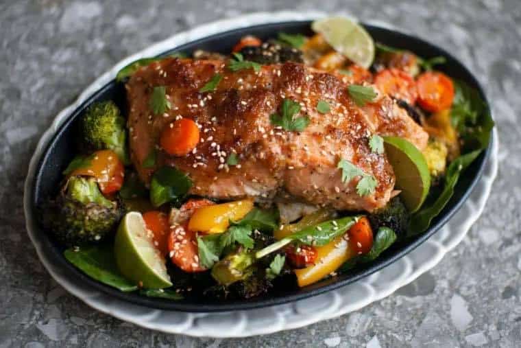 Miso Salmon with broccoli, bell peppers, cherry tomatoes, with lime wedges and cilantro