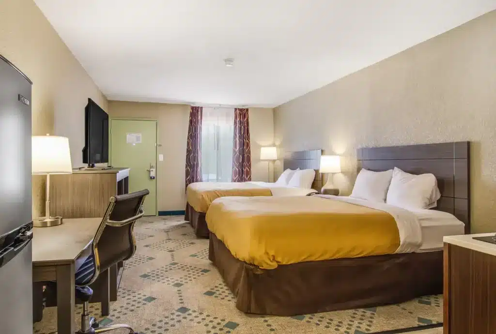 Suburban Studios Guest Room shot across room to exterior door and window from website 03-19-2026