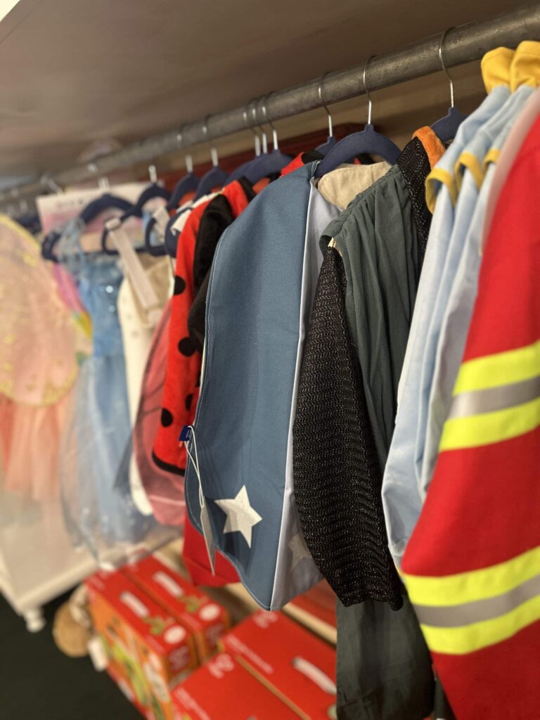 Children's play costumes on hangers on a rack