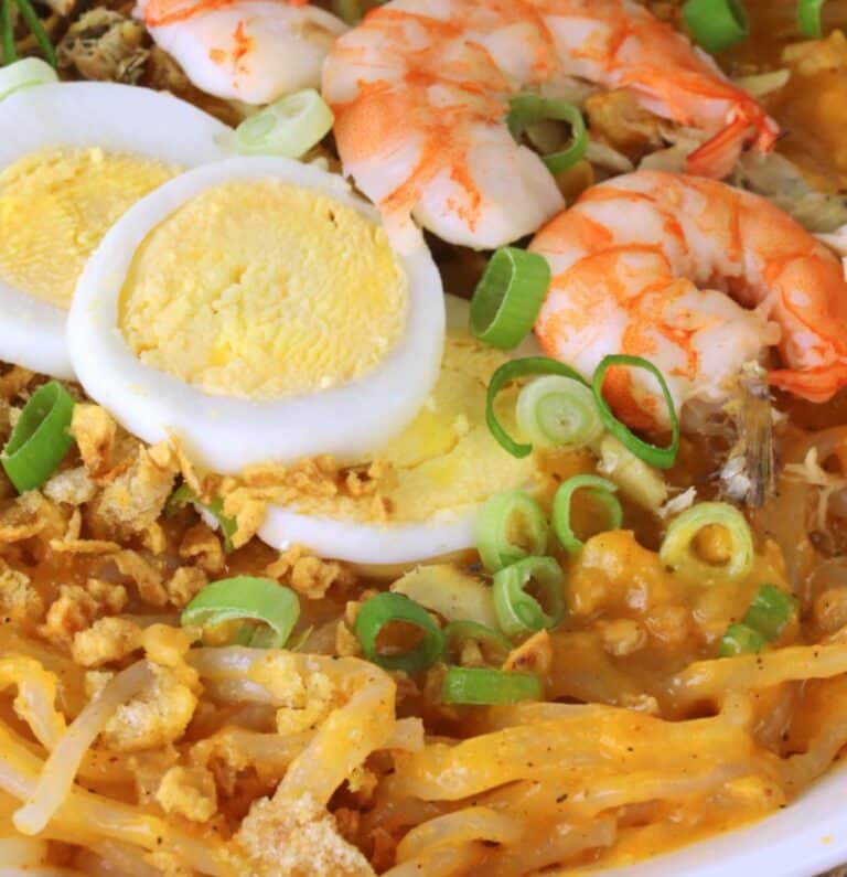 Palabok of cooked shrimp and slice boiled eggs over rice noodles with scallions