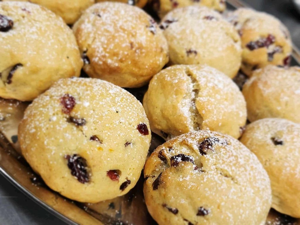A dozen or so ball-shaped cranberry orange cookies dusted with white granulated sugar