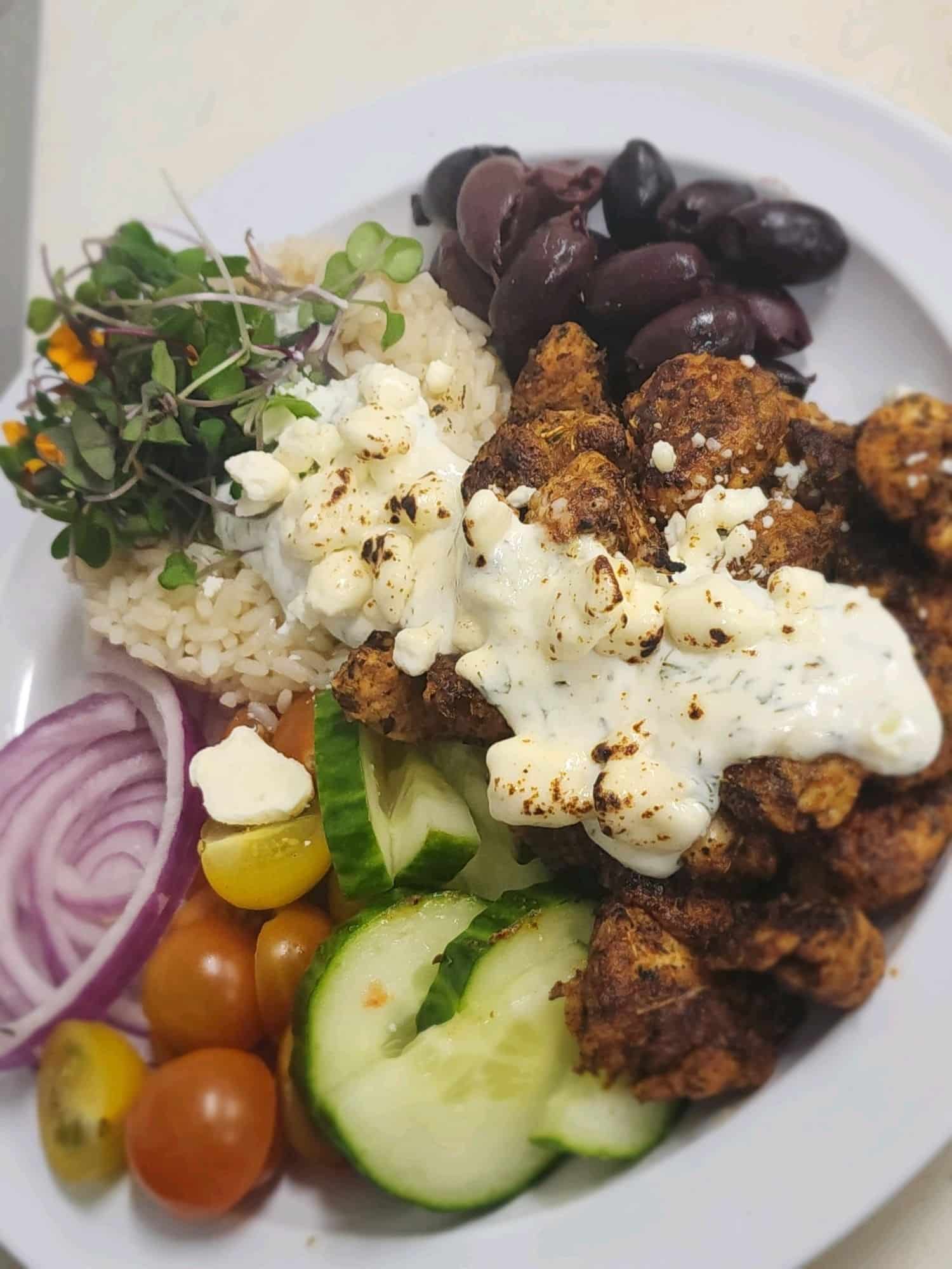 Greek Chicken Souvlaki with feta, red onion, tomato, cucumber slices, black olives and hummus