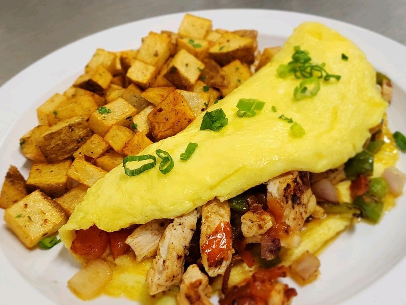Ranchero omelet with spices home fries on a white plate