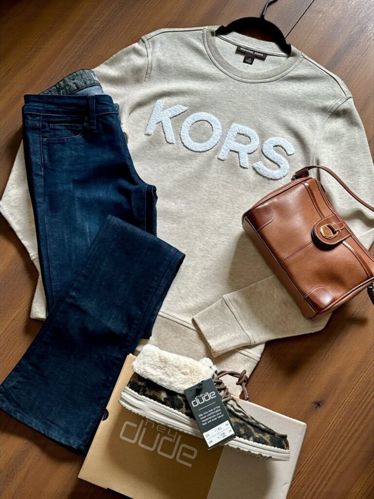Sample consignment outfit with Michael Kors sweatshirt, tan leather bag, Hey Dude brand leopard print shoes, and denim jeans.