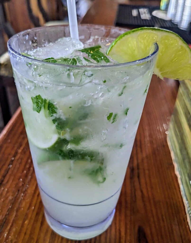 An icy cold Mojito in a tall clear glass with lime wedge and mint garnish