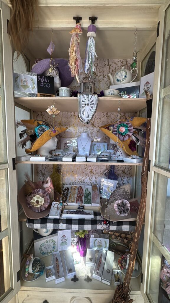 glass front armoire with open doors and jewelry displayed