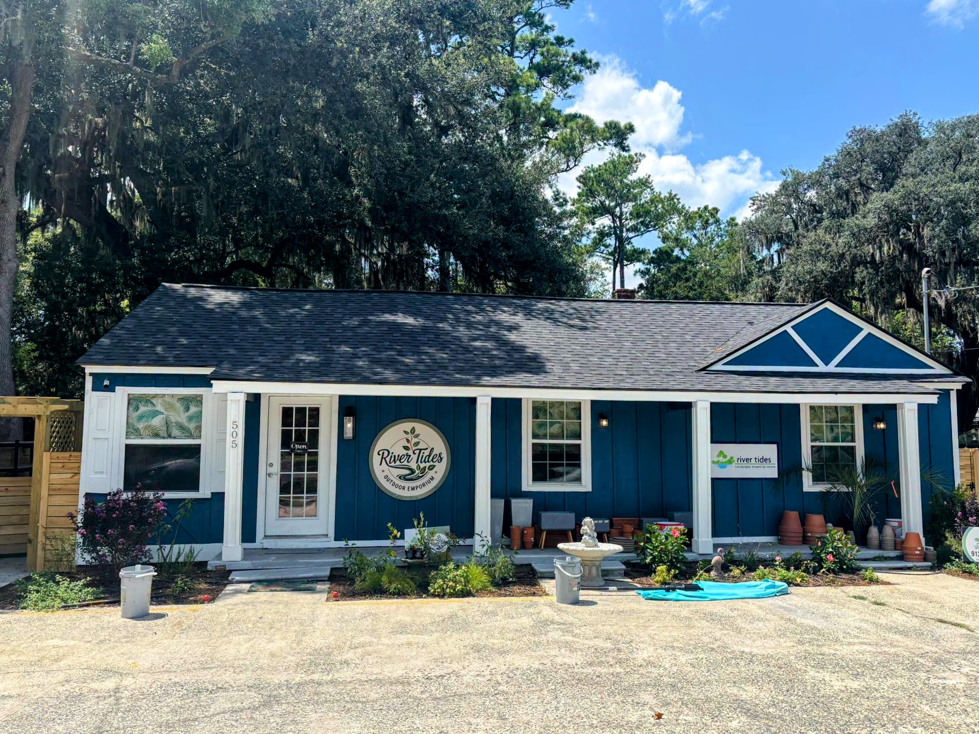 Single story wood house painted blue with white trim, and a roof with two gables.