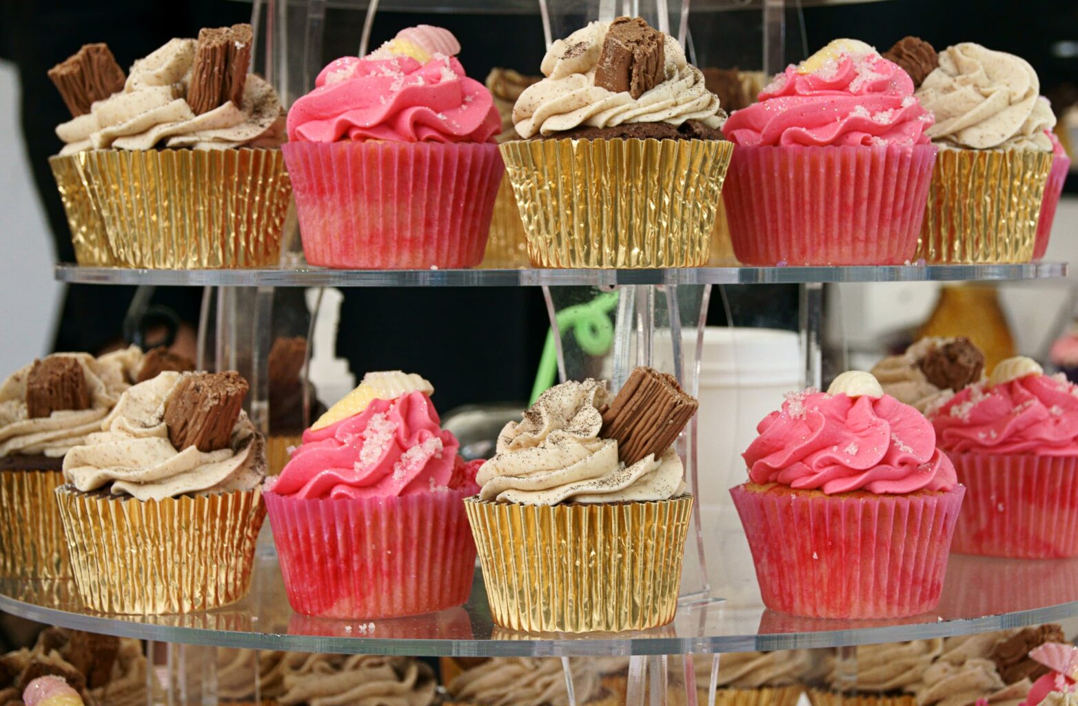 Five pink and five tan cupcakes on display at Super Sweet Bake Shop