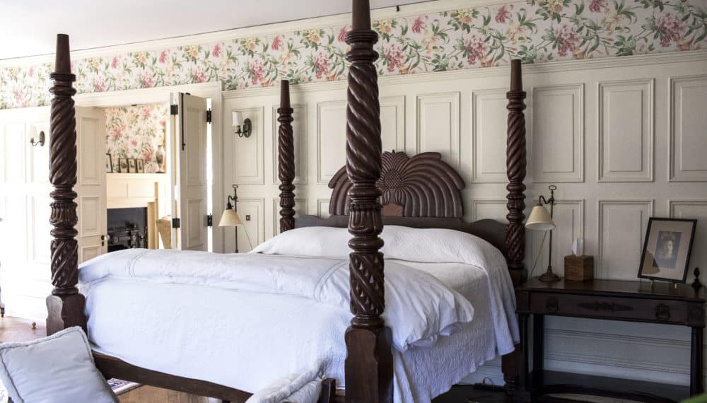 Spacious master suite bedroom featuring a four-poster bed inside the historic Greyfield Inn on Cumberland Island