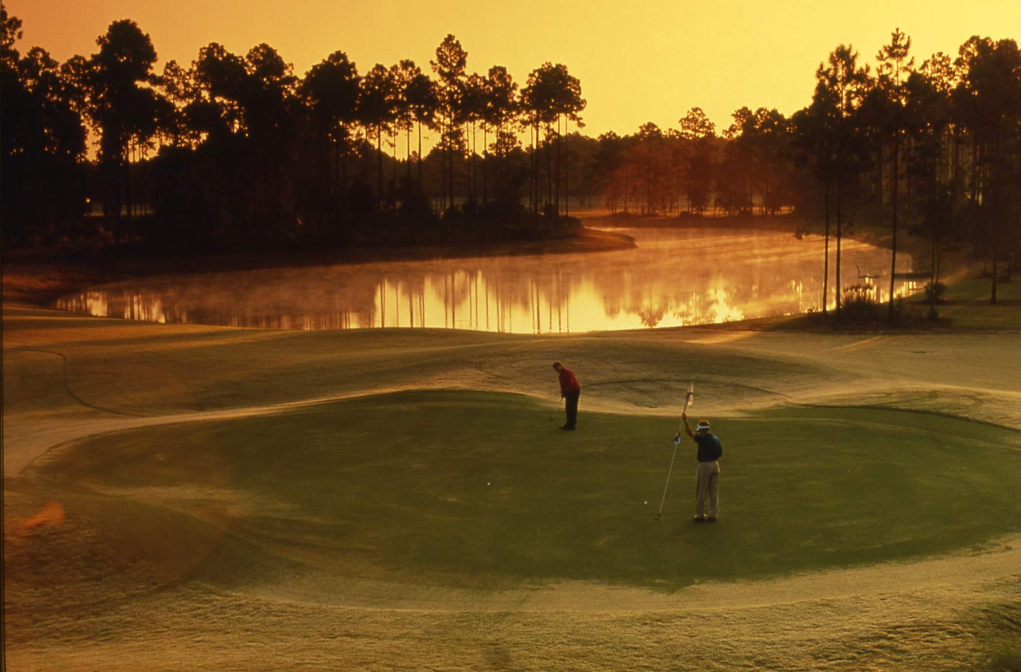 Golfers putting at dawn at Osprey Cove