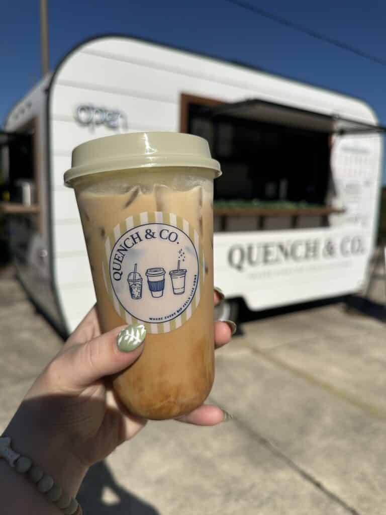 Quench & Co. Coffee Trailer with Close Up of Cookie Dough Iced Latte in a Branded Cup