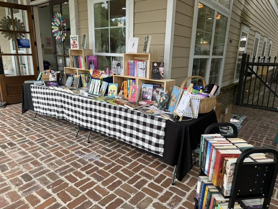 Bookseller's display in front of a shop on a brick tiled porch