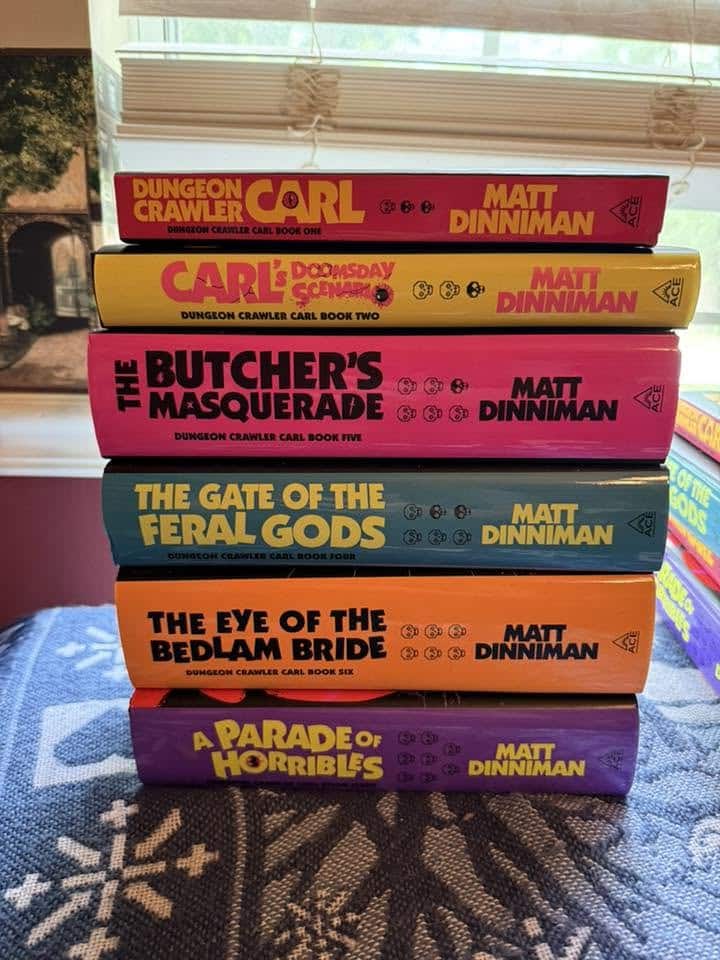 Colorful stack of hardcover books by Matt Dinniman