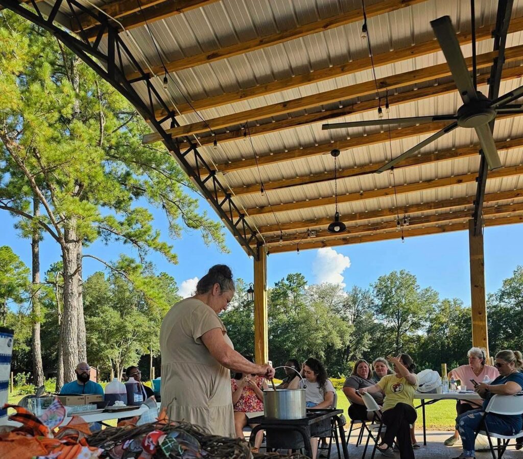 People in a pole barn making muscadine jelly in a pot on a hotplate