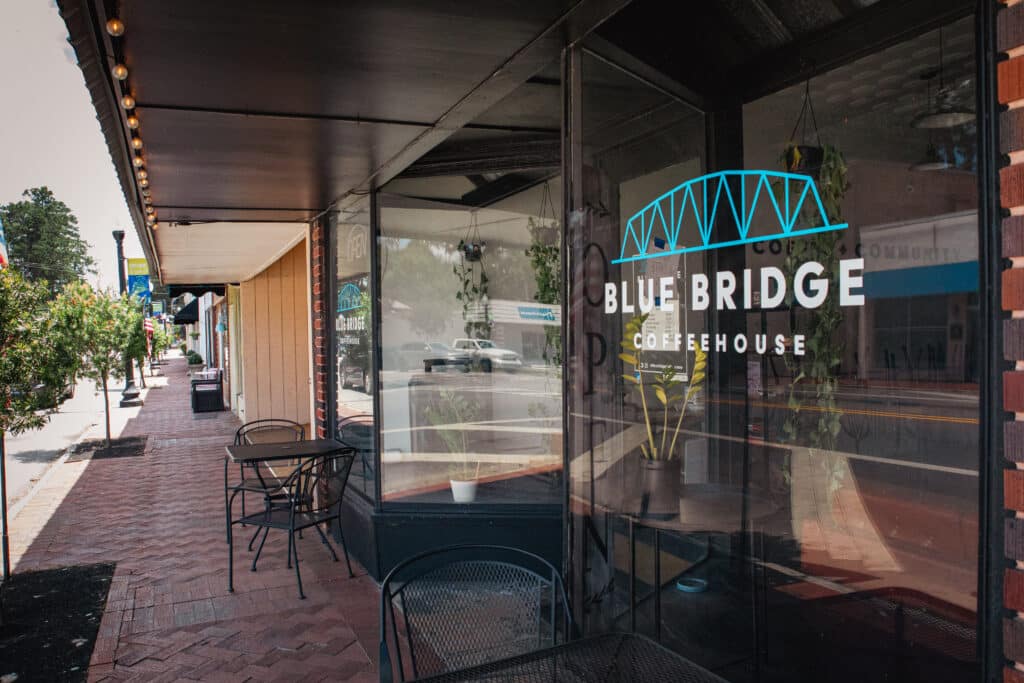 Angled exterior view of Blue Bridge Coffeehouse Storefront with a view down the brick sidewalk.