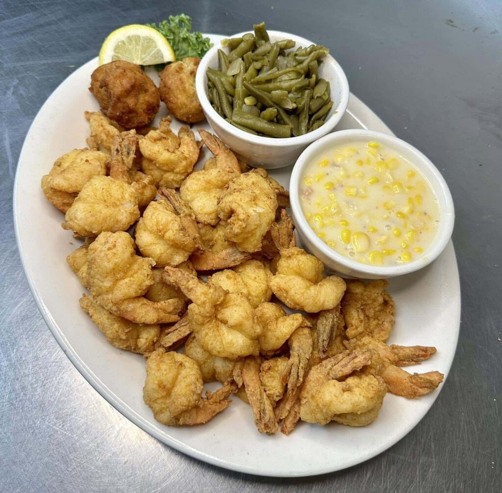 20-piece fried shrimp dinner with two hush puppies, and sides of creamed corn and green beans, with lemon wedge garnish