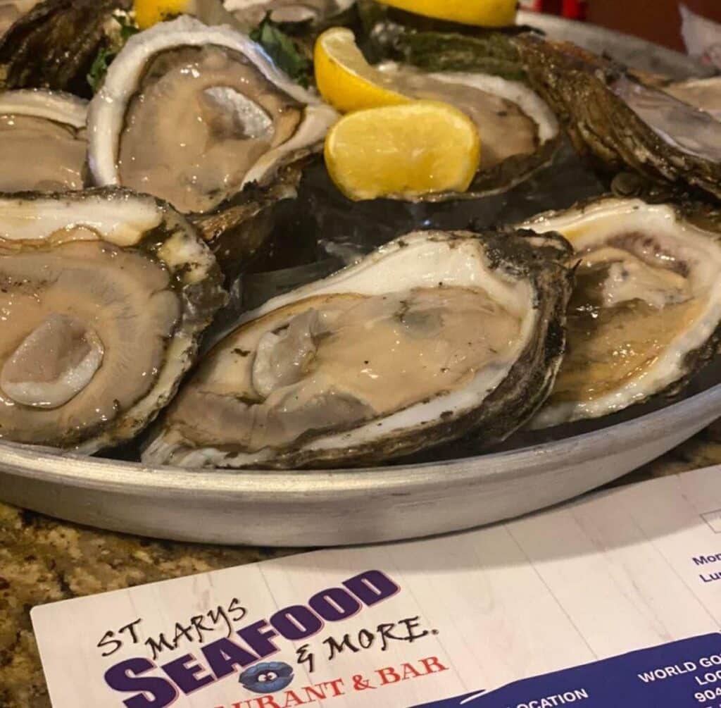 Plate of raw oysters on the half shell with a lemon garnish