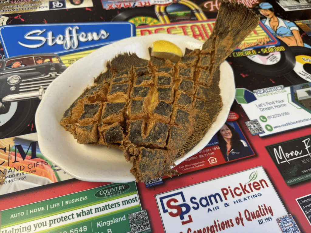 Blackened whole flounder on a white oval plate at Steffens Restaurant