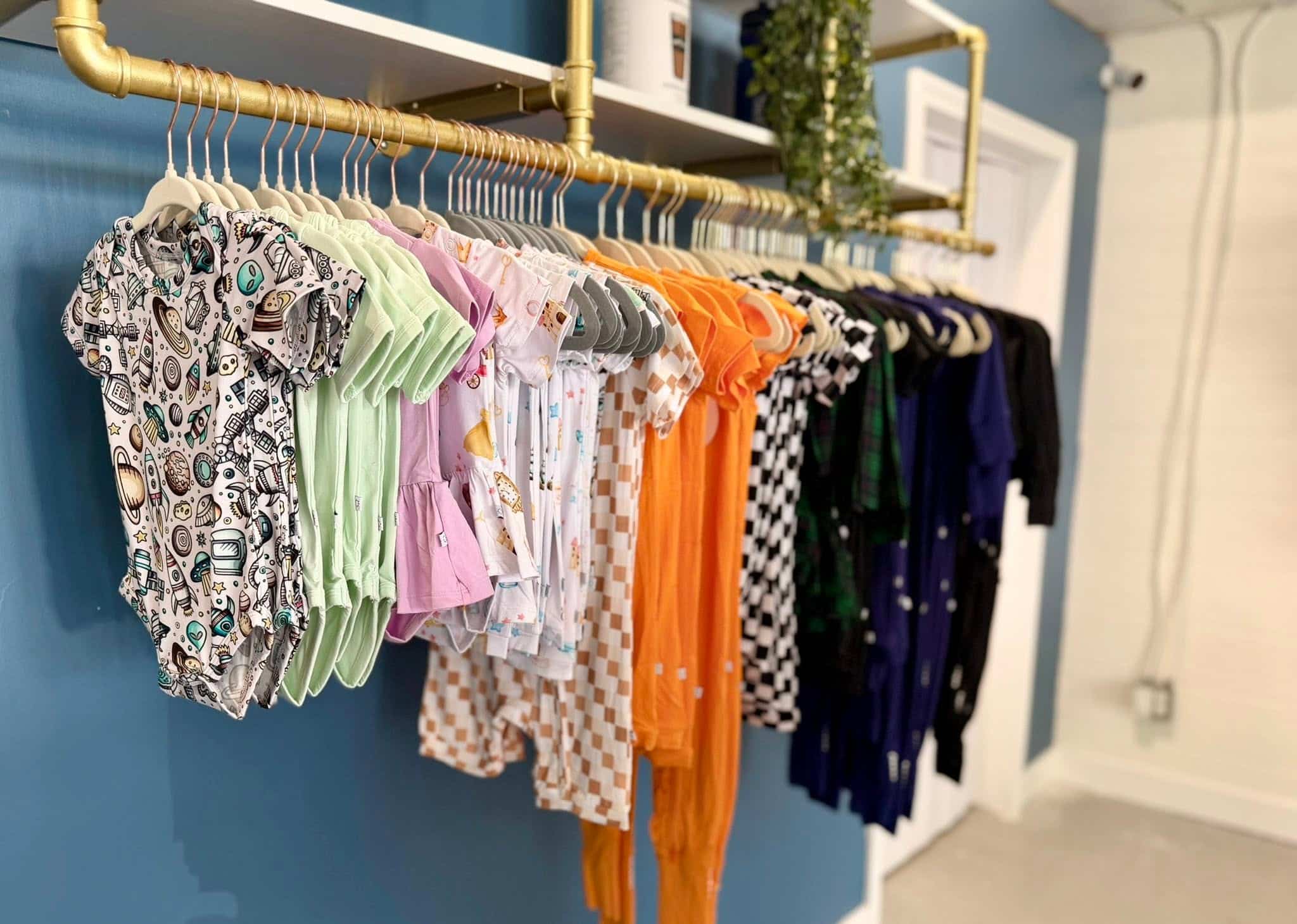 Three Coastal Babies Onesies on a Rack from FB 08-2026