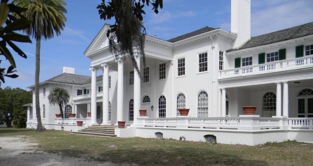 TWo-story white Georgian Revival mansion with columns with terrace and terracotta pots