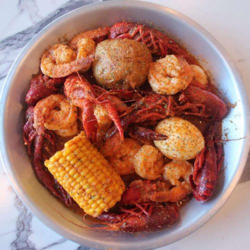 Crawfish and shrimp boil with corn on the cob, potato, and egg